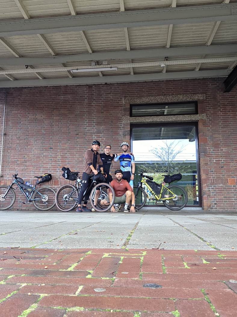 Groepsfoto met bepakte fietsen bij station Naarden‑Bussum