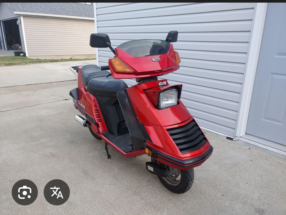 Rode Honda Elite-scooter uit de jaren tachtig op een oprit